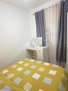 a bedroom with a bed and a desk with a computer at Appartement Ettahrir in Tunis