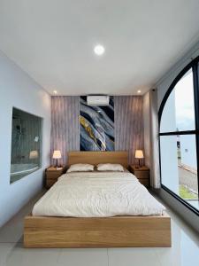 a bedroom with a large bed and a large window at Villa Suarga Loka in Tutugan