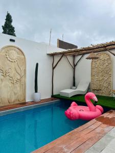 a swimming pool with a pink flamingo in a house at Villa Suarga Loka in Tutugan