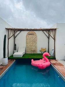 a swimming pool with a pink flamingo in a house at Villa Suarga Loka in Tutugan
