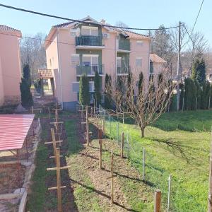 a garden in front of a pink house at Apartman5 in Gornja Toplica