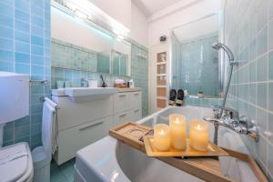 a bathroom with a sink and a tub with candles at Cavour Suite Luxury in Bologna +33 photos