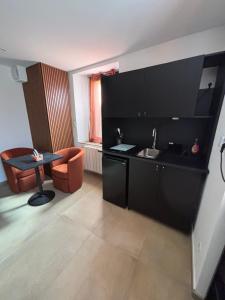 a black kitchen with a sink and a table at esperanza in Vizille