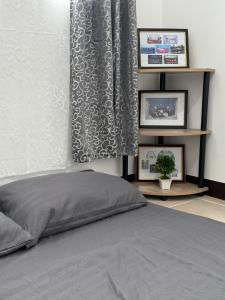 ein Schlafzimmer mit einem Bett und zwei Bildern an der Wand in der Unterkunft Sakura Crib at Xevera Calapan in Camilmil
