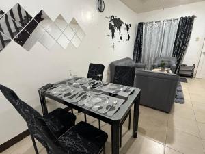 ein Esstisch und Stühle in einem Wohnzimmer in der Unterkunft Sakura Crib at Xevera Calapan in Camilmil