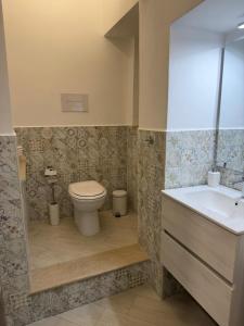 a bathroom with a toilet and a sink at Trinacria Rooms 1 in Carini