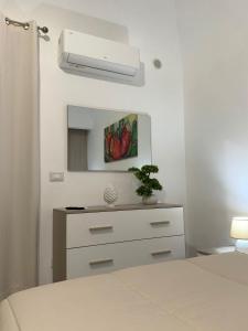 a bedroom with a chest of drawers and a ceiling fan at Trinacria Rooms 1 in Carini +1 photo