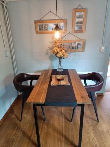 a dining room table with a vase of flowers on it at KNUS tiny gardenhouse in Doorn