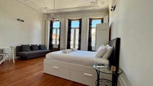 a white bedroom with a bed and a couch at Pombeiro Apartments in Porto