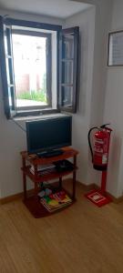 a living room with a tv on a table with a window at Casa dos Avós Palma - Alcoutim in Alcoutim
