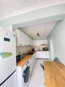 a white kitchen with a table and a refrigerator at Welcome2 in Kobuleti