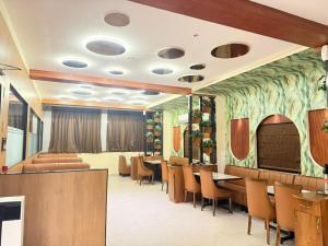 a restaurant with tables and chairs in a room at Hotel SK Chakan Pune in Dehu