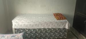 a small bed with two pillows on top of it at Ravi Tomar Homestay in Phalauda