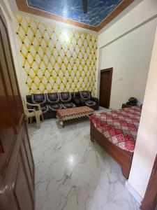 a living room with a couch and a bed at Ravi Tomar Homestay in Phalauda