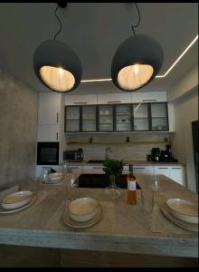 a kitchen with a counter with plates and lights at KANALI HOLIDAYS APARTMENT 5 in Preveza