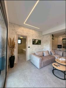 a living room with a couch and a table at KANALI HOLIDAYS APARTMENT 5 in Preveza +4 photos