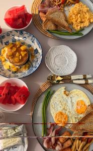 a table with plates of breakfast food on it at Ari & Alki Garden in Ban Nong Nam Khan
