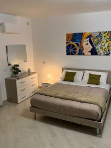 a bedroom with a bed and a dresser and a television at Trinacria Rooms 2 in Carini