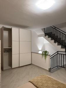 a living room with a staircase and white cabinets at Trinacria Rooms 2 in Carini