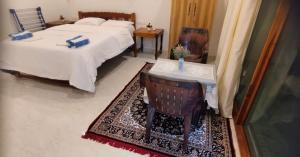 a bedroom with a bed and a table and a chair at Anna Cottages Agonda in Agonda +8 photos