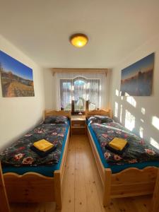 a bedroom with two twin beds and a desk at Chata Štefička in Josefŭv Dŭl