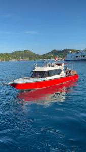 a red and white boat in the water at Komodo Nest Tour in Komodo Labuan Bajo Airport