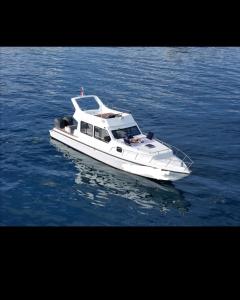 a white boat in the middle of the water at Komodo Nest Tour in Komodo Labuan Bajo Airport