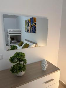 a mirror on a wall above a dresser in a bedroom at Trinacria Rooms 2 in Carini
