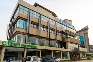 a building with cars parked in front of it at Blue Diamond Residency in Perintalmanna