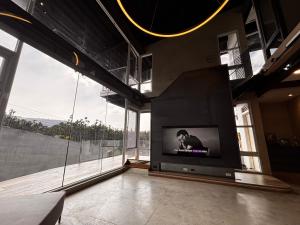 a living room with a large screen tv in a room with large windows at Aernan Inn in Yuchi