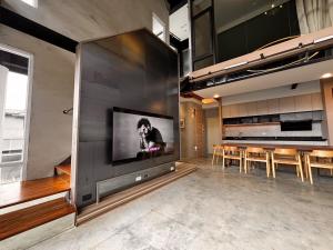 a living room with a large tv on a wall at Aernan Inn in Yuchi