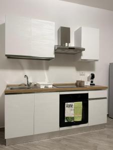 a kitchen with white cabinets and a black oven at Casa Verdi in Carini