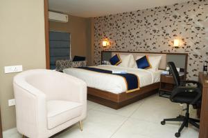 a bedroom with a bed and a desk and a chair at Blue Diamond Residency in Perintalmanna +23 photos