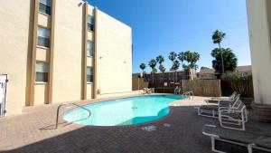 a swimming pool in front of a building at Walkable Location - 99 Steps to Beach - Pool in South Padre Island +69 photos