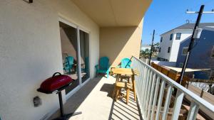 a balcony with a redpot and a table and chairs at Walkable Location - 99 Steps to Beach - Pool in South Padre Island