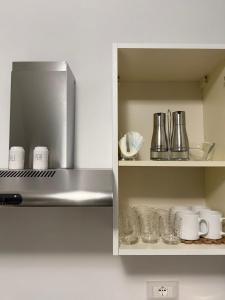 a kitchen with a shelf with cups and utensils at Casa Verdi in Carini
