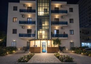 a large white building with a front entrance at night at Illyrian Hotel in Lezhë