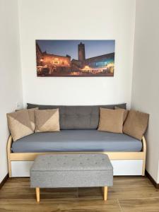 a couch with a ottoman in a living room at Easy Bergamo Apartment in Bergamo +5 photos