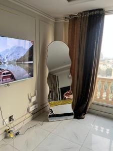 a living room with a chair in front of a window at stunning studio apartment in Rāmkot