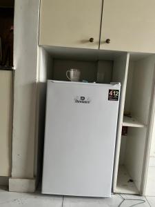 a white refrigerator in a kitchen with its door open at stunning studio apartment in Rāmkot +2 photos