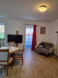 a living room with a table and a couch at Appartement Purzel in Mauerbach