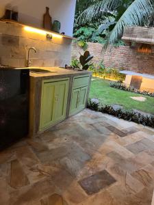 an outdoor kitchen with green cabinets in a backyard at Villa Semoga in Tanjung