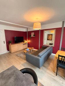 a living room with a couch and a tv at Appartement Duplex The Lighthouse in Châteaulin