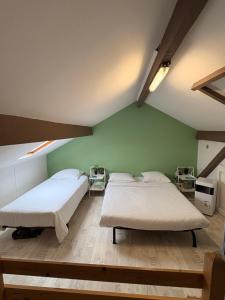 two beds in a room with green walls at Appartement Duplex The Lighthouse in Châteaulin
