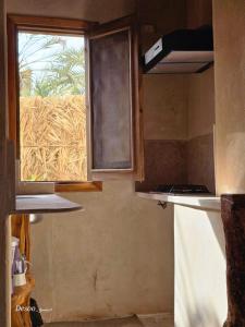 a kitchen with a window and a counter top at Hidden Garden House in Siwa