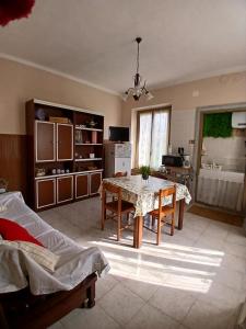 a living room with a table and a kitchen at Casa La V G in Almese