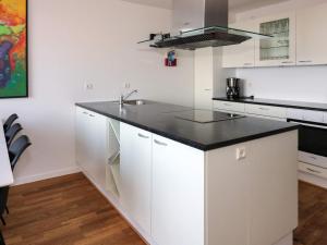 a kitchen with white cabinets and a black counter top at 5 star holiday home in Hadsund in Øster Hurup