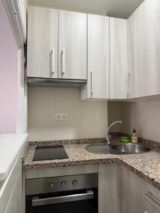 a kitchen with white cabinets and a sink at LUZ DEL MAR Almuñécar Centro Playa in Almuñécar +6 photos