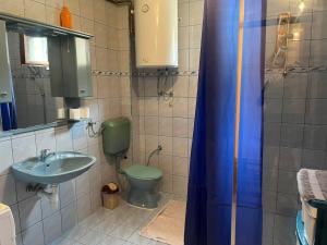 a bathroom with a green toilet and a sink at Apartman Buric in Vogošća