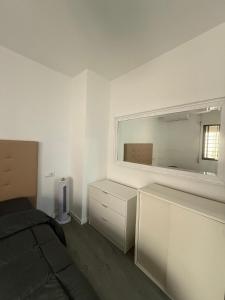 a white room with a bed and a mirror at LUZ DEL MAR Almuñécar Centro Playa in Almuñécar
